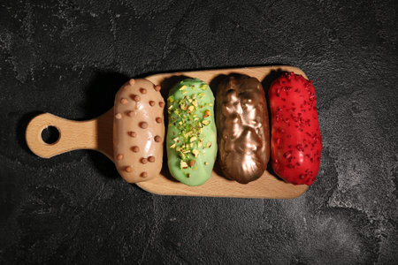 Sweet tasty eclairs on dark background