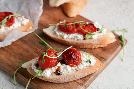 Wooden board of tasty tomato bruschetta with ricotta on white backgroundの写真素材