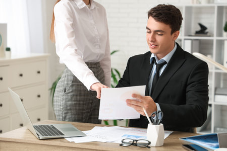 Male economist and secretary working with diagrams in officeの写真素材