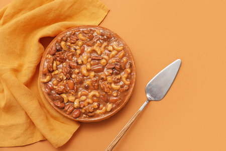 Sweet tart with different nuts and caramel on brown backgroundの写真素材