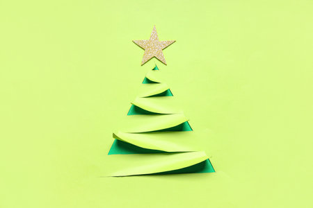 Christmas tree made of paper with golden star on green backgroundの写真素材