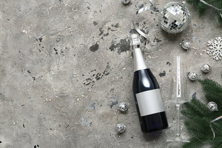 Bottle of champagne with Christmas decorations and fir branches on grunge gray backgroundの写真素材