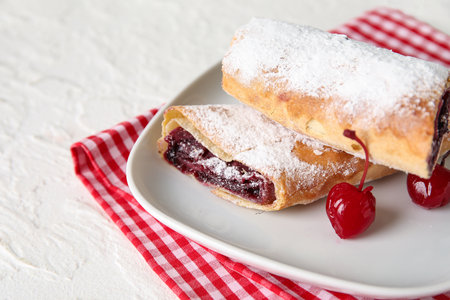 Plate with sweet cherry strudel on white backgroundの写真素材