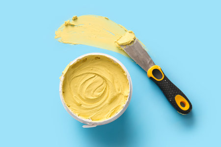 Knife with can of putty on blue backgroundの写真素材