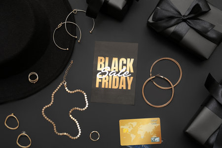 Card with text BLACK FRIDAY, stylish female accessories and credit card on dark backgroundの写真素材