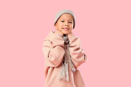 Cute little Asian boy in warm clothes on pink backgroundの写真素材