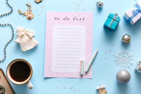 Blank to-do list with coffee cup and Christmas decor on blue backgroundの写真素材