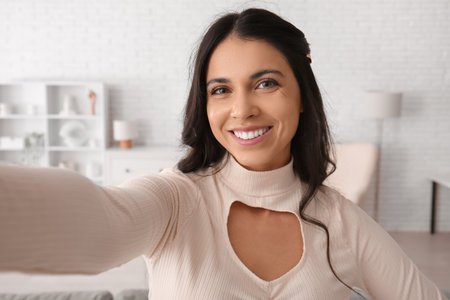 Pretty young woman taking selfie at home, closeupの写真素材