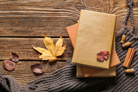 Stack of books, scarf and autumn decor on wooden backgroundの写真素材