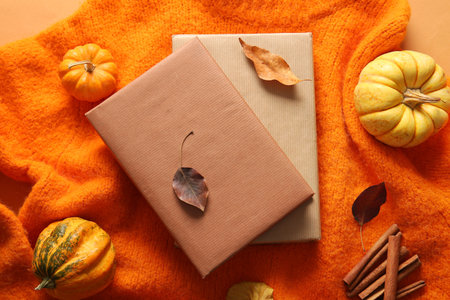 Composition with books, pumpkins and fallen leaves on warm sweaterの写真素材