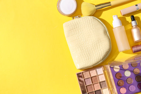 Cosmetic bag and makeup products on yellow backgroundの写真素材