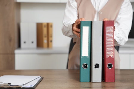 Young businesswoman with folders on table in office, closeupの写真素材