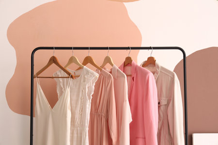 Rack with stylish clothes near color wallの写真素材