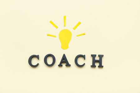 Word COACH with paper light bulb on beige backgroundの写真素材
