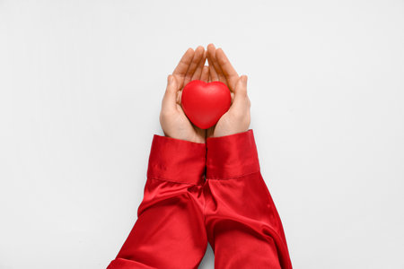 Female hands with red heart on white background. Valentine's Day celebrationの写真素材