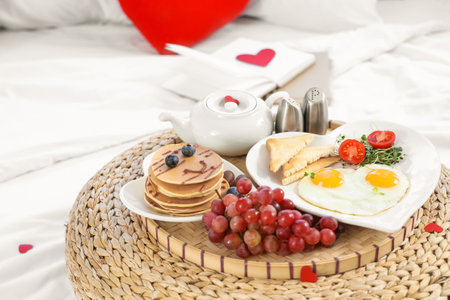 Tasty breakfast for Valentine's Day on pouf in bedroom, closeupの写真素材