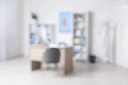 Blurred view of medical office with doctor's workplace and shelf unitsの写真素材