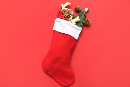 Christmas sock with reindeer horns, cones and fir tree on red background. Top viewの写真素材