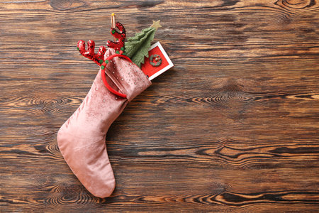 Christmas sock with reindeer horns, fir tree and mini door on wooden backgroundの写真素材
