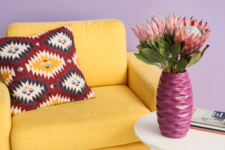 Vase with protea flowers and magazines on table in living room, closeupの写真素材