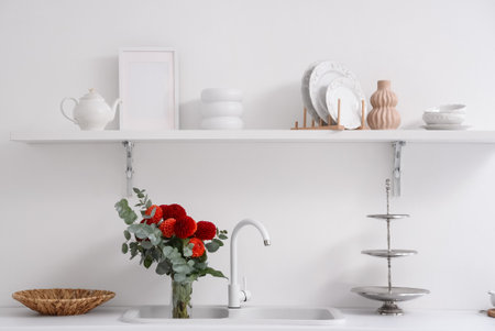 Red dahlia flowers in sink in kitchenの写真素材