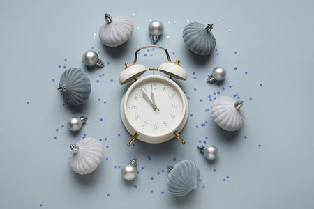 Composition with alarm clock, decorations and confetti on gray background. Christmas countdown...