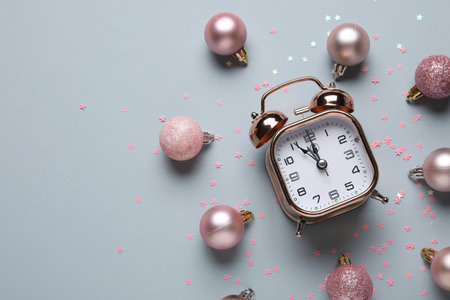 Composition with alarm clock, pink decorations and confetti on gray background. Christmas countdown concept. Top viewの写真素材