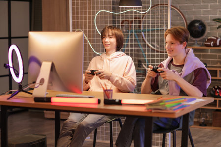Male students playing video game in bedroom at night