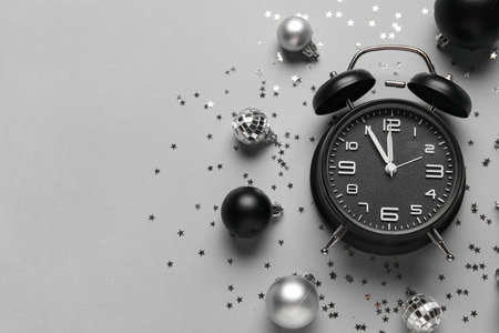 Composition with black alarm clock, decorations and confetti on gray background. Christmas countdown concept. Top viewの写真素材