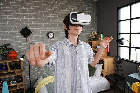 Male student using VR glasses in bedroom