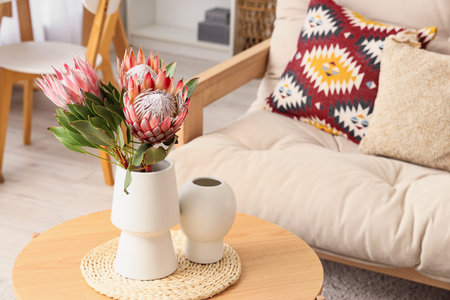 Vase with beautiful protea flowers on coffee table in living roomの写真素材