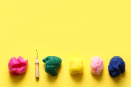 Set of wool for felting and needle on yellow backgroundの写真素材