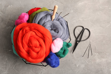 Basket with different wool for felting, needles and scissors on grunge backgroundの写真素材