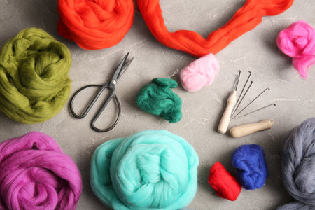 Composition with different wool for felting, needles and scissors on grunge backgroundの写真素材