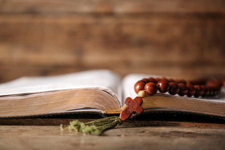 Open Bible and rosary beads on wooden table, closeupの写真素材