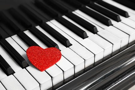 Red heart on piano keys, closeup. Valentine's Day celebrationの写真素材