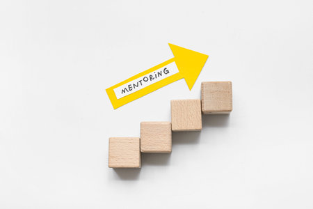 Arrow with word MENTORING and wooden cubes on white background