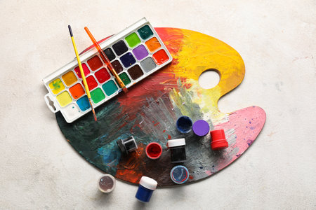 Artist brushes, palette and paints on white grunge backgroundの写真素材