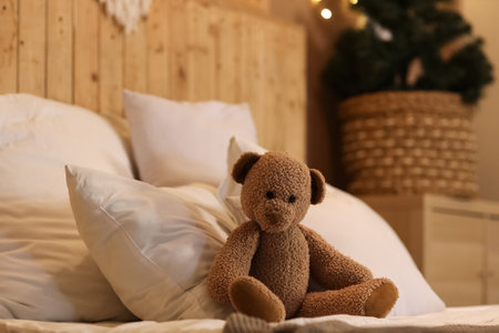 Cute teddy bear on bed in bedroomの写真素材