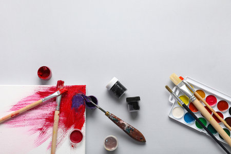 Artist brushes with canvas and paints on gray backgroundの写真素材