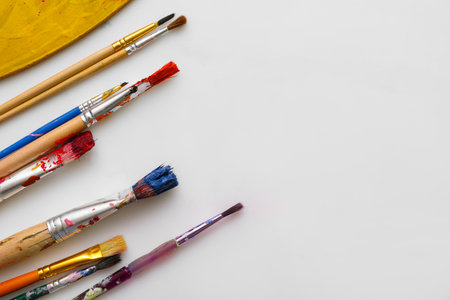 Artist brushes with paints on white backgroundの写真素材