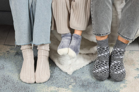 Parents and their little daughters in warm socks at home, closeupの写真素材