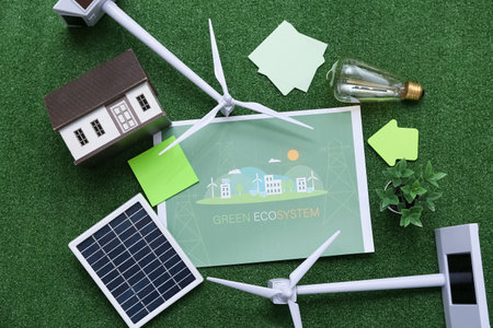 Wind turbines with solar panel, house model and light bulb on grass. Green Energy conceptの写真素材
