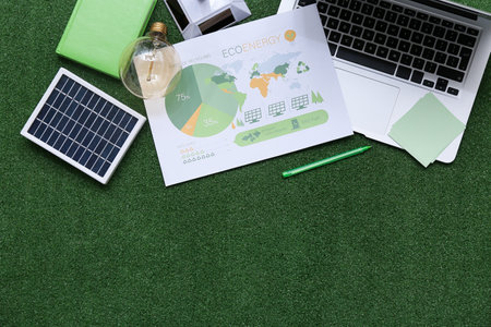Laptop with stationery and solar panel on grass. Green Energy conceptの写真素材