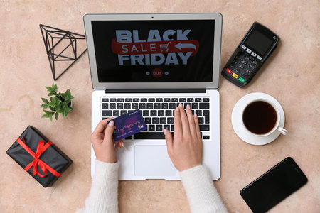 Woman with credit card and laptop shopping online on beige grunge background. Black Friday Sale