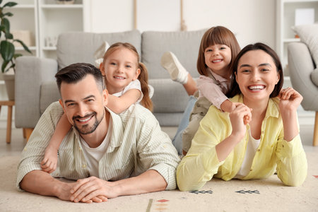 Beautiful happy family lying on floor at homeの写真素材