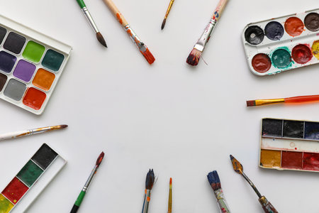 Frame made from artist brushes and paints on white backgroundの写真素材