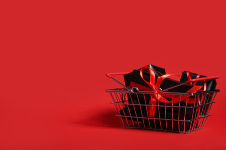 Shopping basket with gift boxes on red background. Black Friday saleの写真素材