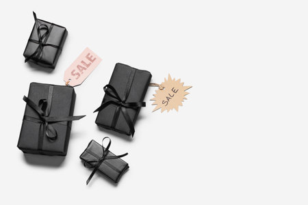Gift boxes with labels on white background. Black Friday sale. Top view