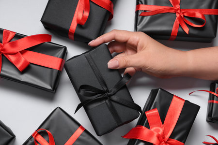 Female hand with gift boxes on white background. Black Friday sale. Top viewの写真素材